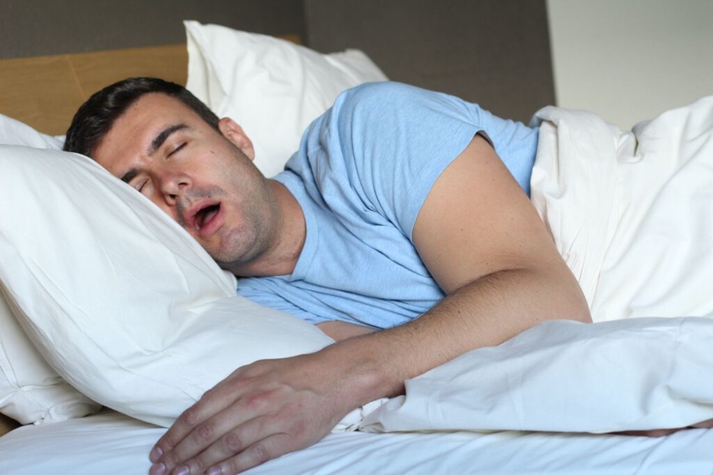 man sleeping in bed with his mouth open snoring sleep apnea dentist in Plano Texas